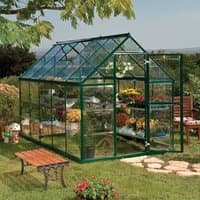 Green polycarbonate walk-in greenhouse with clear panels, pitched roof, and open double doors on a grassy lawn.