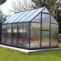 Grey greenhouse with clear panels, sloped roof, and black frame, 6' x 10', set on a grassy area.