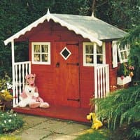 Red wooden playhouse with white trim, small porch, diamond window, and two side windows, surrounded by plush toys.