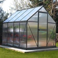 Grey greenhouse with clear panels, sloped roof, and metal frame, measuring 6' x 8', set on a grassy area.
