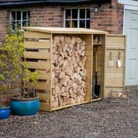 Wooden logstore with slatted sides, tool storage section, and pitched roof, filled with stacked firewood.