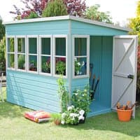 Teal wooden garden potting shed with large windows, single door, and flat roof, surrounded by plants and gardening tools.