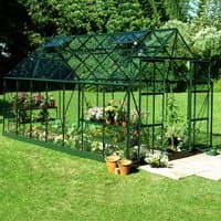 Green Halls Magnum 814 greenhouse with glass panels, pitched roof, and metal frame, set on a grassy lawn.