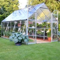 Silver Palram Canopia Balance 8x12 greenhouse with clear panels, sturdy frame, and open door, set on a grassy lawn.