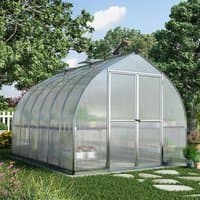 Silver Palram Canopia Bella greenhouse with curved roof, clear panels, and double doors in a garden setting.