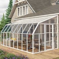 Clear 8x16 Palram Canopia Rion sunroom with white frame, glass panels, attached to house, featuring patio furniture.
