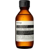 Amber bottle of Aesop B & Tea Balancing Toner, black cap, white label with text, 100 ml for sensitive skin.