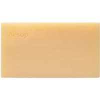 Beige rectangular Aesop body cleansing slab soap with embossed brand name on the surface.