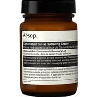 Brown glass jar with black lid, Aesop Camellia Nut Facial Hydrating Cream label in white, 120 ml.