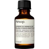 Amber glass bottle of Aesop Catherine Oil Burner Blend with black cap and white label detailing spicy essential oil blend.