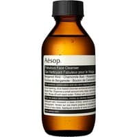 Amber bottle of Aesop Fabulous Face Cleanser with black cap and white label detailing product information.