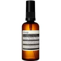 Amber bottle of Aesop Moroccan Neroli Shaving Serum with black pump and white label, 100 ml.