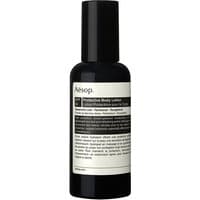 Black Aesop body lotion bottle with white label, SPF 50, 150 ml, sleek cylindrical design.