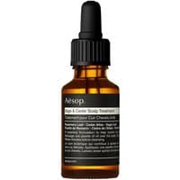 Amber dropper bottle labeled "Aesop Sage & Cedar Scalp Treatment," black cap, white and black text.