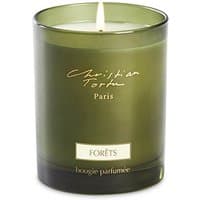 Green glass jar candle with white wax, labeled "Christian Tortu Paris Forêts bougie parfumée" in elegant script.