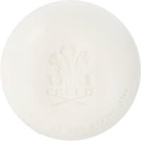 White round soap with embossed Creed logo and text, "Silver Mountain Water Savon 150 g," elegant and minimalist design.