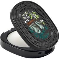 Black oval compact of Diptyque Do Son Solid Perfume with floral design and engraved text.