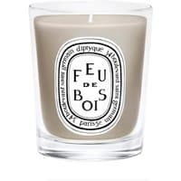 Clear glass jar with gray wax, featuring Diptyque's "Feu de Bois" label, 70 g woody-scented candle.