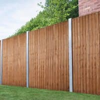 Forest vertical closeboard fence panel, 6' x 5'6, brown wood with vertical slats and metal posts, against greenery.