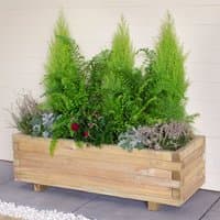 Wooden garden planter box with stacked slats, filled with green ferns and small flowering plants.