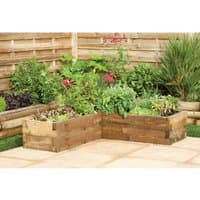 Wooden corner raised bed with tiered design, filled with green plants and flowers, set on a patio.