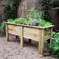 Wooden garden planter with deep root design, 6'x2', natural finish, elevated on sturdy legs, filled with greenery.