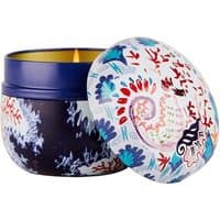 Fragonard Menthe Basilic candle in blue jar with colorful floral lid, lit with a warm glow.