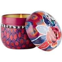 Fragonard candle with floral-patterned tin, vibrant red and blue design, lit amber oriental scent.