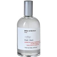 Clear glass bottle with silver cap, white label, and black text, "Shanti Shanti Eau de Parfum" by Miller et Bertaux.