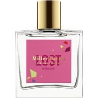 Clear glass bottle with gold cap, pink label reading "Miller Harris Lost in the City" for unisex aromatic perfume.