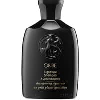 Black Oribe Signature Shampoo bottle, travel size, with embossed logo and gold text.