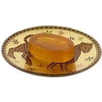 Amber soap on decorative glass plate with leopard design, by Ortigia.