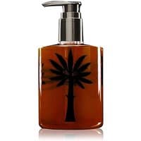 Amber-colored Ortigia Ambra Nera liquid soap in a 300 ml bottle with a black palm tree design and silver pump.
