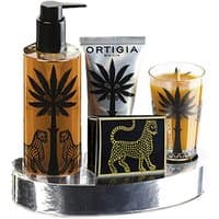 Ortigia Ambra Nera gift set with palm tree design, includes pump bottle, tube, candle, and soap on silver tray.