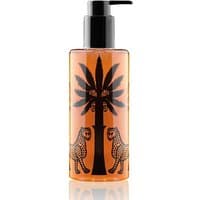Amber bottle of Ortigia Ambra Nera shower gel with black palm and leopard design, black pump top.