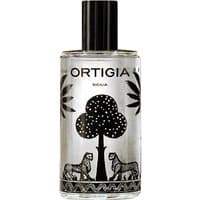 Clear glass bottle with black cap, featuring black palm tree and leopard design, labeled "Ortigia Melograno Room Essence."