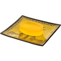 Yellow soap on square glass plate with gold and black animal design, by Ortigia.