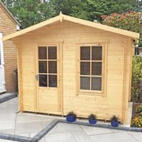 Wooden log cabin summerhouse with double doors, window panes, pitched roof, and natural finish, set on a patio.