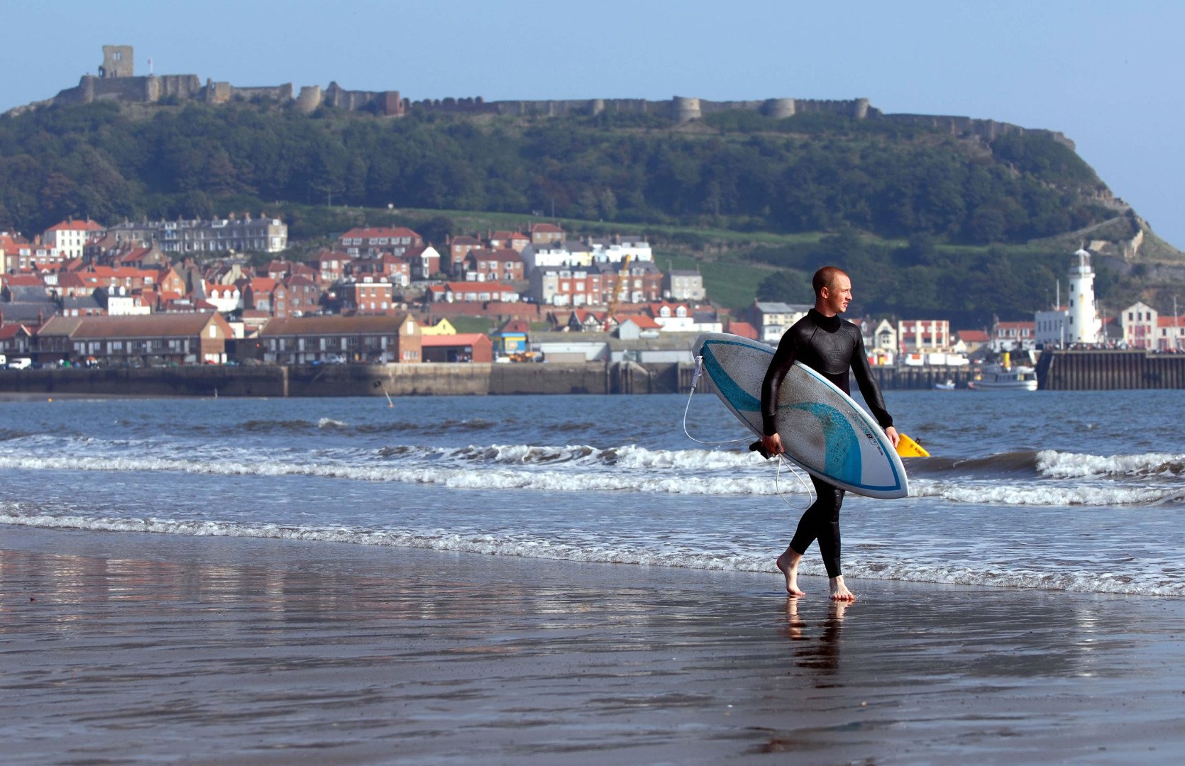 Surfer carrying surf board at South Bay Scarborough
