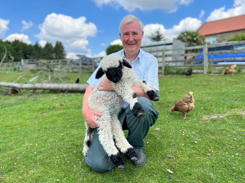 Image name 7 Peter with a Valais Blacknose lamb ©Peter the 5 image from the post Book Giveaway: "The Tales and Tails of a Yorkshire Vet" by Peter Wright in Yorkshire.com.